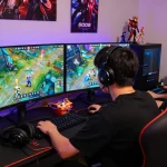 Engaged gamer immersed in Go88 game session with vibrant dual screens, snacks, and competitive atmosphere.
