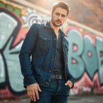 Model wearing premium denim jacket and jeans against an urban backdrop.